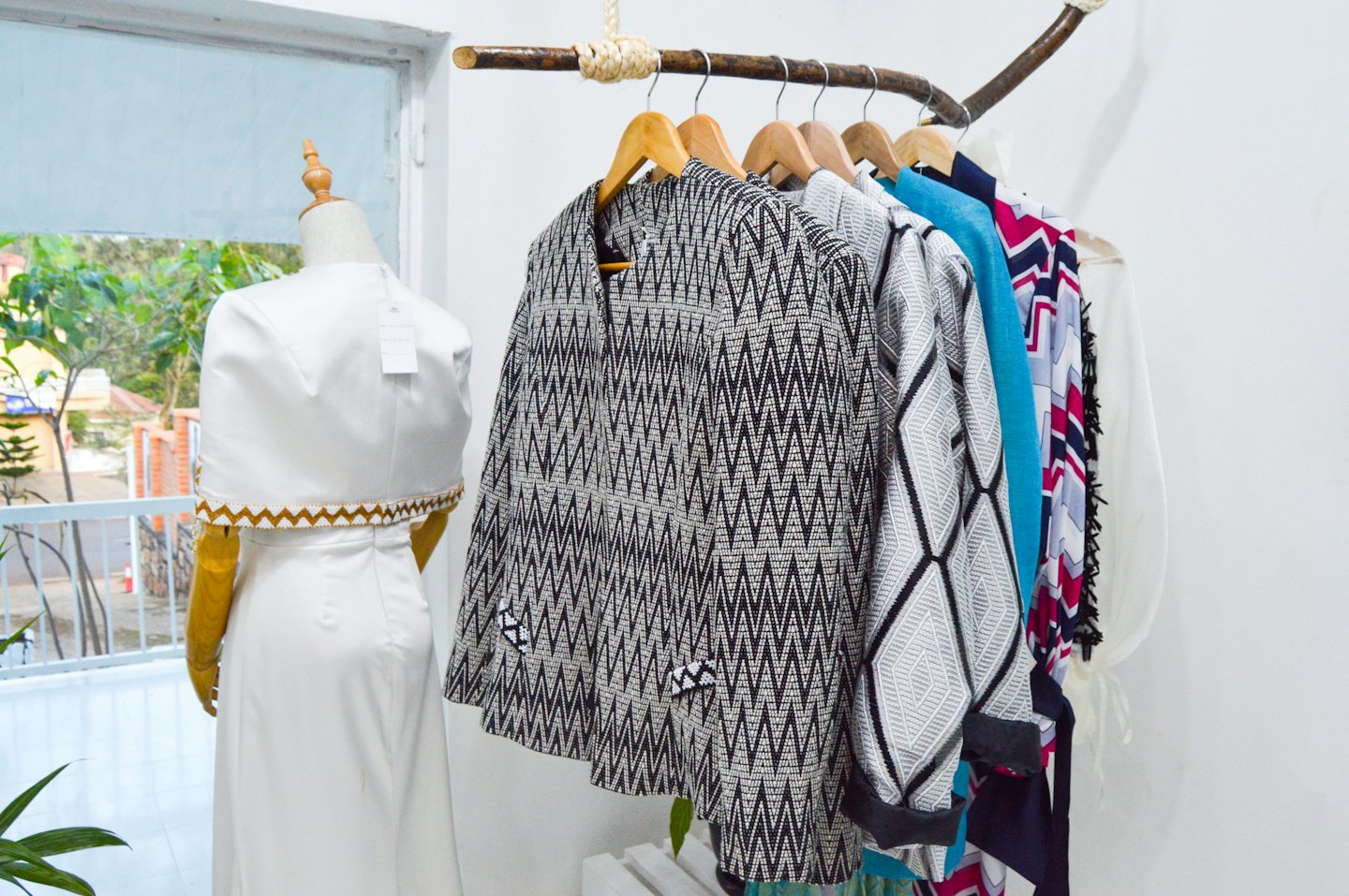 Mannequin in a boutique wearing a white dress with patterned clothes.