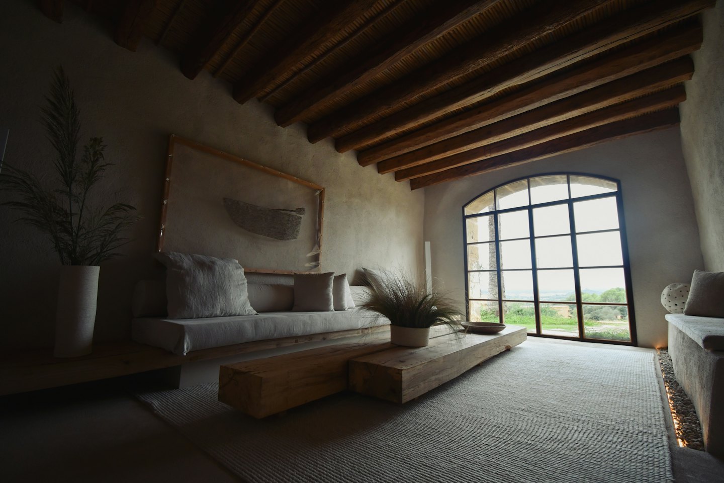 Living room with sofa, coffee table, and arched window.